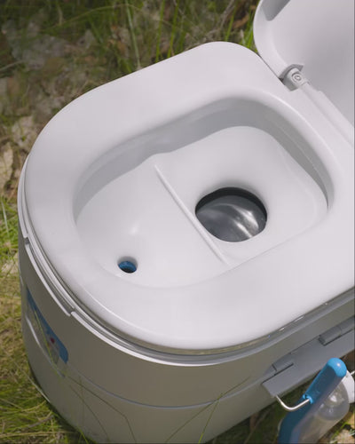 Open GottaGo bowl on grass, showing the moulded divider that sends liquids to the front opening and solids to the rear.